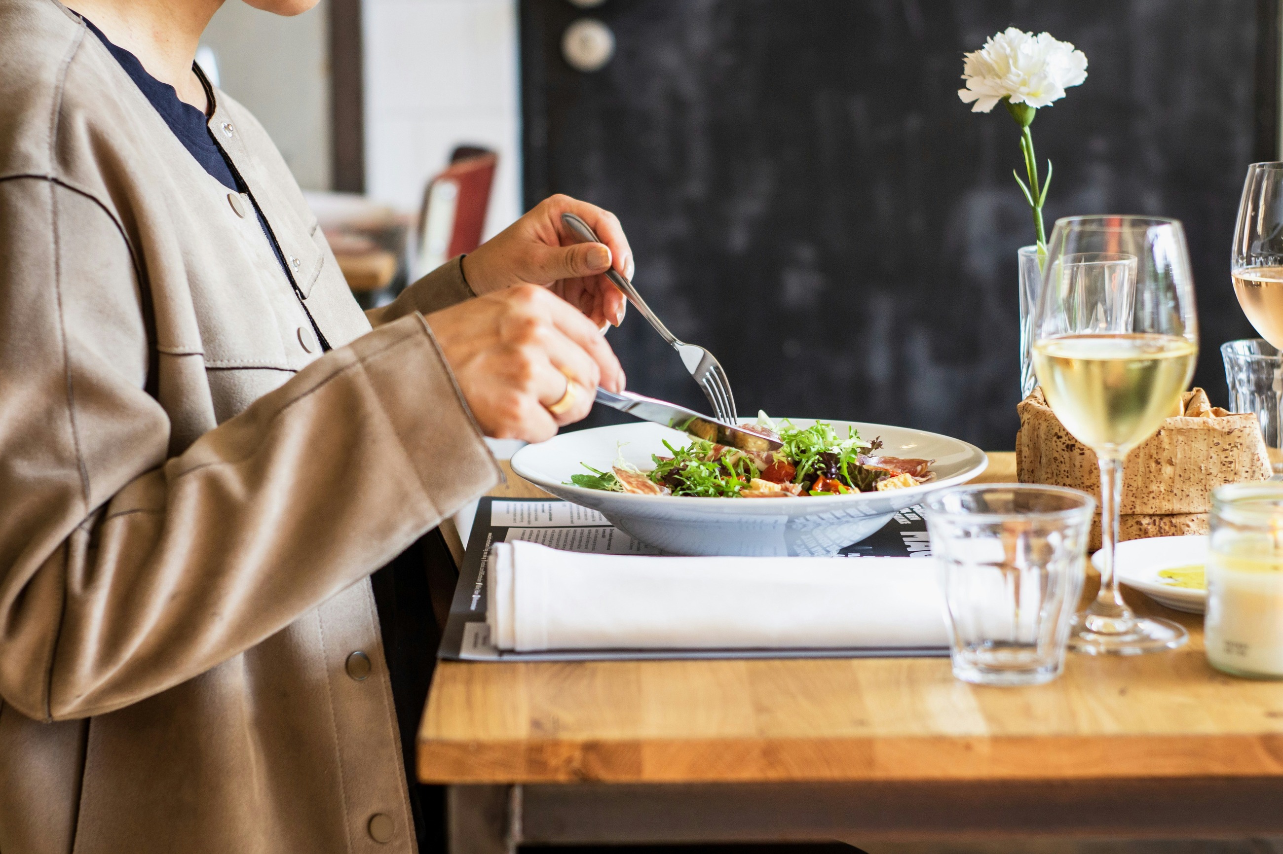 a person sitting at a table with wine glasses